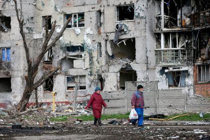 Dos personas pasan ante un edificio bombardeado en Mariupol, el día 22.