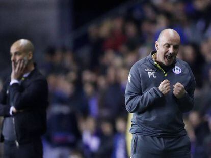 El entrenador del Wigan, Paul Cook, celebra el gol junto a Guardiola.