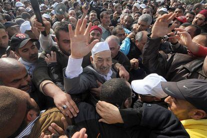 El líder de En Nahda, Rachid Ghanuchi (centro), saluda a su llegada al aeropuerto de Túnez.