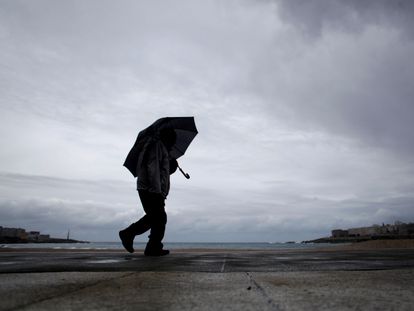 Un hombre camina por el paseo marítimo de A Coruña.