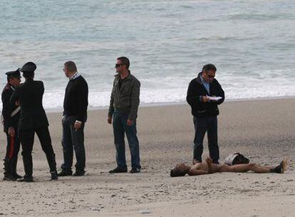 Investigadores de la policía, junto al cadaver de un inmigrante ilegal en la playa de Roceella Jonica.