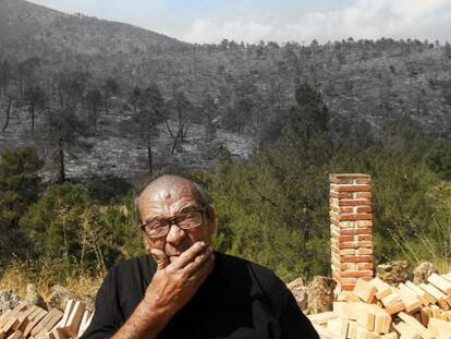 Mariano Gonz&aacute;lez ante el paisaje humeante que se divisa desde su finca junto al r&iacute;o Cofio. 