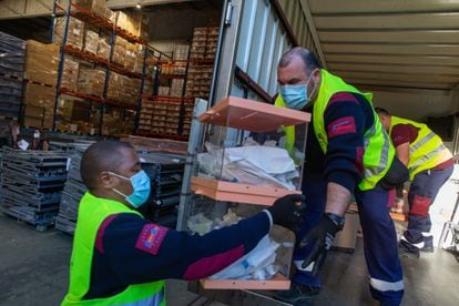 Operarios de los talleres municipales del Ayuntamiento de Barcelona trabajan en el almacén donde se guarda el material electoral del 14-F.