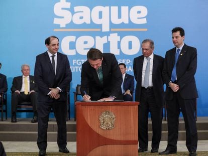 El presidente Jair Bolsonaro en el centro, en el acto de presentación del cambio en las reglas de retirada de fondos de reserva de los trabajadores.