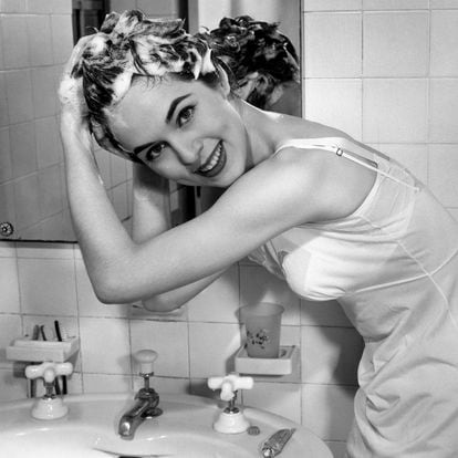 Woman washing hair in bathroom sink