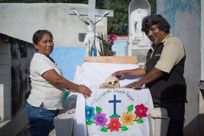 Luis Fernando Couch López limpia lo restos de su padre, acompañado de su esposa.