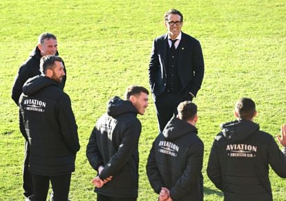 Ryan Reynolds, copropietario del Wrexham, habla con sus jugadores mientras esperan la llegada de Carlos III y Camila, el pasado diciembre. Fundado en 1864, el Wrexham es el tercer club de fútbol profesional más antiguo del mundo. Fue adquirido por los actores Ryan Reynolds y Rob McElhenney a finales de 2020.