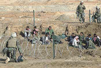 Militares estadounidenses vigilan a prisioneros iraquíes en el centro de Irak.