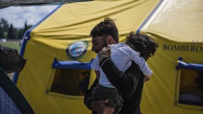 Osman, el niño afectado por una parálisis cerebral, con su padre.