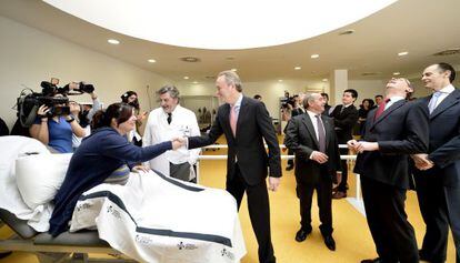 Alberto Fabra saluda a una mujer en la sala de rehabilitaci&oacute;n y Alfonso Alonso mira al techo en la visita al hospital de Ll&iacute;ria.