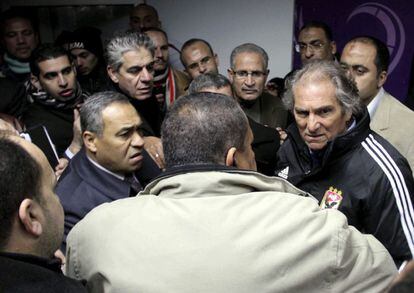 El entrenador del Al Ahli, el portugués Manuel Jose (segundo por la derecha), busca refugio en una zona de seguridad mientras policías y aficionados egipcios se enfrentan en el estadio de Port Said.