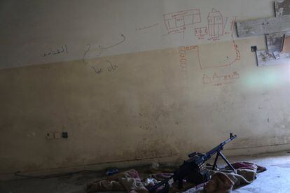 Una ametralladora, en el suelo, junto a un mapa dibujado para mostrar distancias en el nido de un francotirador, en un edificio controlado por las fuerzas iraquíes que luchan contra el Estado Islámico en Mosul, Irak.