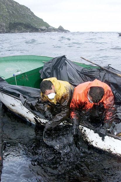 Pescadores, mariscadores y voluntarios de las Rías Bajas recogen pegotes de fuel del vertido por el petrolero "Prestige", en aguas de Cangas de Morrazo (Pontevedra). Al fondo, las islas Cíes.