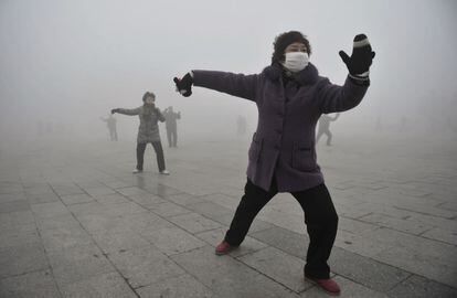 Fuyang, China, 14 de enero de 2013. Una mujer hace sus ejercicios matinales con una máscara en la cara en Fuyang, en la provincia china de Anhui, debido a el alto nivel de polución. La fuerte contaminación, que alcanzó a la capital, llevó a que el Gobierno instara a la población a no salir a la calle. La niebla tóxica (smog) continuó ahogando al país durante varias semanas.