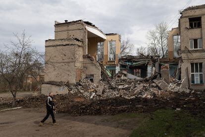 A neighbor walks past Kramatorsk school number 15, destroyed by a Russian ballistic missile. 