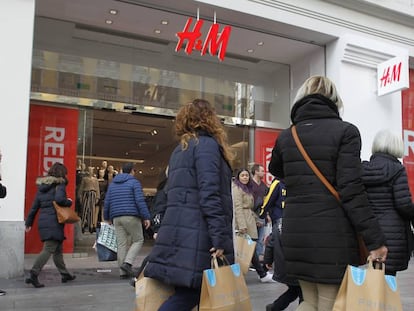 Clientes, por la Gran Vía de Madrid, frente a un establecimiento de H&M.