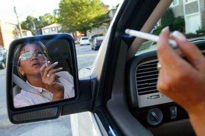 Una mujer fuma dentro de su coche en Nueva York.