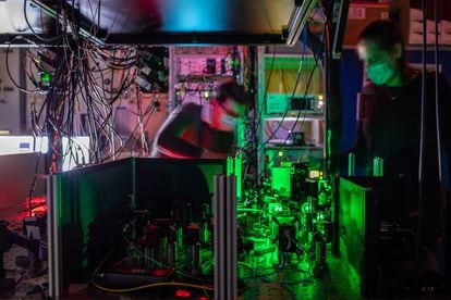 Investigadores de QuTecn trabajan en un nodo de una red cuántica, donde los espejos y filtros guían los rayos láser hacia el chip de diamante.