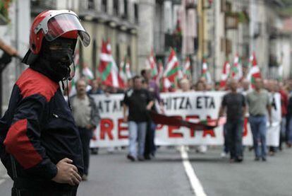 Un <b><i>ertzaina</b></i> vigila una manifestación <b><i>abertzale</b></i> en Lizarra en 2007.