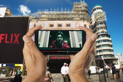 Un móvil reproduce una de las escenas de 'La casa de papel' rodada en la plaza madrileña de Callao.