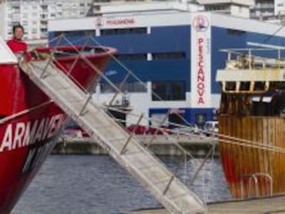 Entre unos barcos de pesca del Puerto de Vigo la nave de fr&iacute;o de Pescanova, en la avenida de Beiramar.