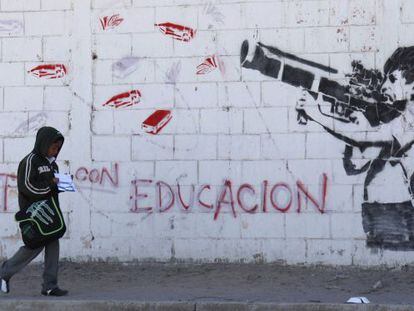Un mural en Ciudad Ju&aacute;rez muestra a un ni&ntilde;o disparando un arma cargada con materiales escolares.