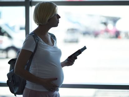 Una mujer embarazada en un aeropuerto.