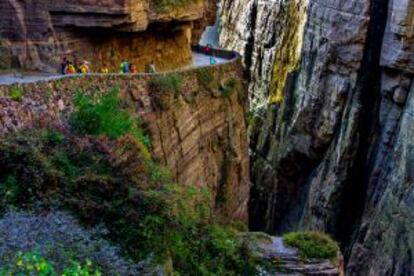 Turistas caminando por la carretera del túnel de Guoliang, tallada en la montaña de Wanxian, en la provincia china de Henan.