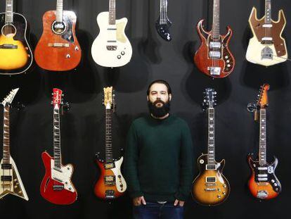 Israel Dom&iacute;nguez ante varias de las guitarras que vende en su tienda.