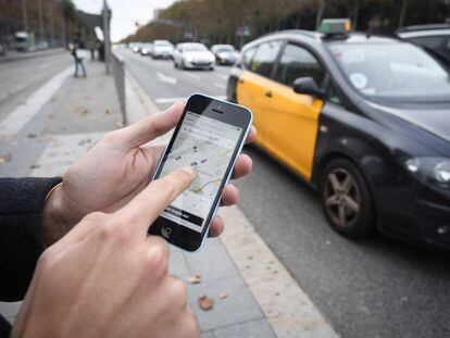 Un vianant sol·licita un cotxe a través d'Uber a la Diagonal de Barcelona.