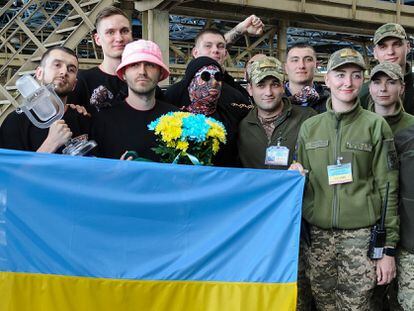 Kalush Orchestra posa con el micrófono de cristal junto a militares ucranios el 16 de mayo de 2022, al regresar a su país tras su victoria en Eurovisión 2022.