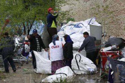 Los primeros residentes del asentamiento cargan en abril materiales reciclados en el camión de Cosmin.