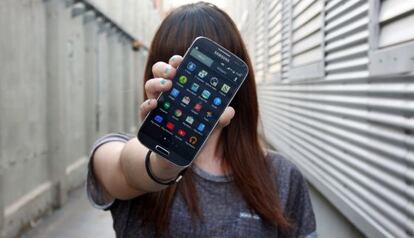 Una joven muestra la pantalla de su teléfono inteligente.
