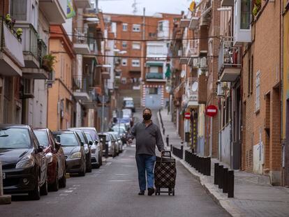 Un hombre con carrito de la compra baja por una calle del barrio Zofío, una de las 37 zonas confinadas en Madrid.