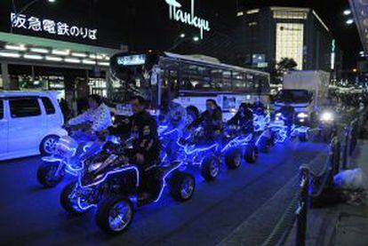 Un grupo de personas montando 'quads' iluminados por las calles del barrio de Gion, en Kioto (Japón).