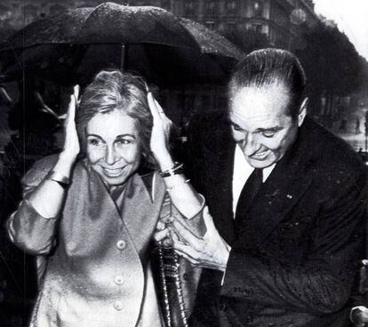 Chirac ayuda a protegerse de la lluvia a la reina Sofía durante una muestra de cultura española en París, en octubre de 1987.
