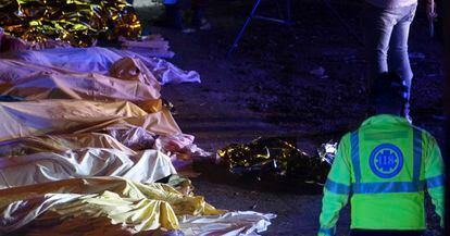 Personal de emergencias junto a los cadáveres de varias de las víctimas del accidente, en Mestre. 