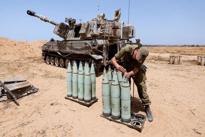 Un soldado israelí revisa las municiones junto a una unidad de artillería móvil en un campo cercano de la frontera con la Franja de Gaza.