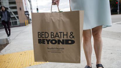 A customer stands for a photograph with a shopping bag outside of a Bed Bath & Beyond Inc. store in Los Angeles, California, U.S., on Monday, Sept. 19, 2016. Bed Bath & Beyond Inc. is scheduled to release earnings figures on Sept. 21. Photographer: Patrick T. Fallon/Bloomberg