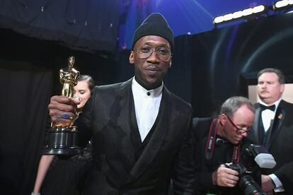 Mahershala Ali, que llevó uno de los looks masculinos más peculiares de la noche sobre la alfombra roja, posa flamante con su Oscar a mejor actor por su papel en Green Book.