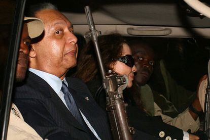 Jean-Claude Duvalier, protegido por guardias armados, tras aterrizar el domingo en Puerto Príncipe procedente de París.