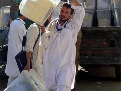Funcionarios afganos descargan urnas en Jalalabad.