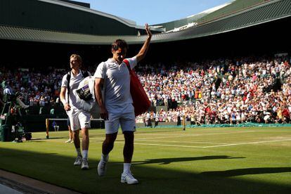 Federer se despide del público de la Pista 1, con Anderson detrás, este miércoles en Wimbledon.