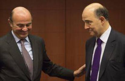 El ministro español de Economía, Luis De Guindos (izda), conversa con su homólogo francés Pierre Moscovici, durante la reunión del Eurogrupo celebrada el pasado lunes en la sede de la Unión Europea, Bruselas.