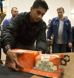Un investigador malasio recoge las cajas negras del MH17 derribado el jueves sobre territorio ucranio. / Dmitry Lovetsky (AP)