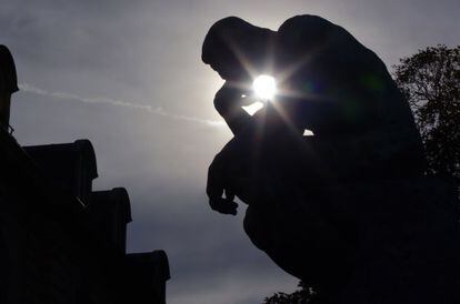 El sol del atardecer se cuela entre las formas de 'El pensador' de Rodin, situado en los jardines de su museo, en París.