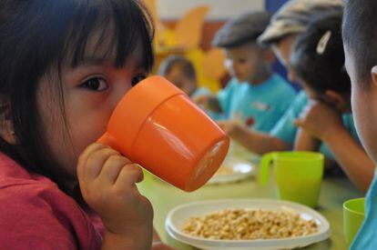 Un grupo de niños en un comedor escolar.