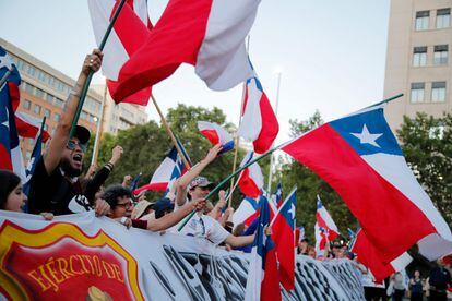 Ciudadanos celebran hoy los resultados del plebiscito constitucional, en Santiago.