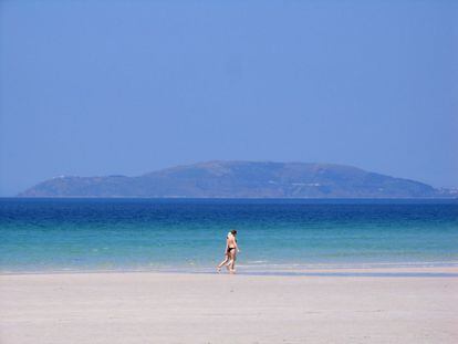 La playa de Carnota, con el cabo de Finisterre despuntando a lo lejos, se muestra propicia para largos paseos.