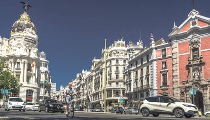 Un ciclista pasa por la Gran Vía de Madrid.